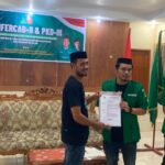 Wakil Sekretaris PW GP Ansor Maluku Utara, Mursid Puko, menyerahkan Surat Keputusan (SK) kepengurusan kepada Ketua GP Ansor Halmahera Selatan terpilih, Muhlis Usman, (foto: Istimewa).