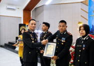 Kapolres Halmahera Selatan, AKBP Hendra Gunawan, menyerahkan penghargaan kepada Kapolsek Gane Barat, Ipda Ruslan Anwar, pada peringatan Hari Bhayangkara ke-80 Tahun 2026.
